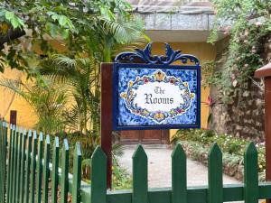 a sign in front of a green fence at Navya Niwas - The Rooms in Dehradun +21 photos