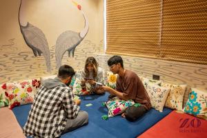 a group of three people sitting on a bed at Zo Selections Jaipur by Zostel in Jaipur