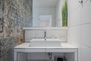 ein weißes Badezimmer mit Waschbecken und Spiegel in der Unterkunft Elflein Quartier in Potsdam + 43 Fotos