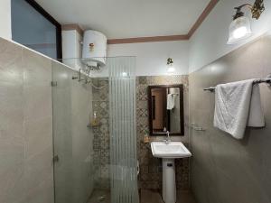 a bathroom with a shower and a sink and a shower at Navya Niwas - The Rooms in Dehradun