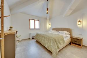 a white bedroom with a bed and a desk at Ferienwohnungen Sutorman in Bar