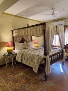 a bedroom with a canopy bed with two lamps at Navya Niwas - The Rooms in Dehradun