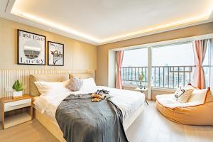 a bedroom with a bed and a large window at Yangji Yeju in Zhuhai