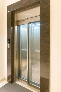 a glass elevator door in a building at Hotel Avani Grand in Zahirābād