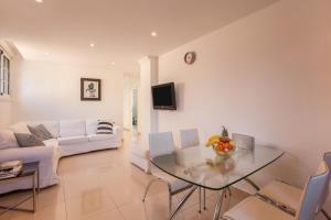 a living room with a glass table and a couch at Casa Orquídea 7 in El Médano