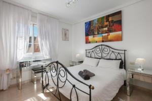 a bedroom with a white bed with a black frame at Casa Orquídea 7 in El Médano +28 photos