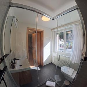 a bathroom with a sink and a toilet and a mirror at Design-Studio nahe der Piste Lenzerheide in Lenzerheide +5 photos