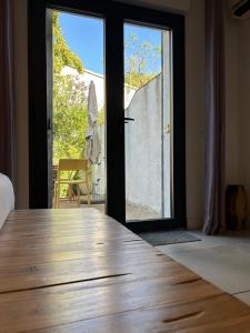 a room with a wooden table and a sliding glass door at Chambres d’hôtes Casarena in Porto-Vecchio