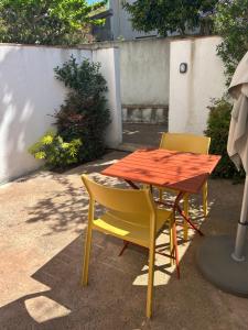 two chairs and a table with a red table and chairs at Chambres d’hôtes Casarena in Porto-Vecchio