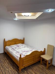 a bed and a chair in a room at Apartament Floare de Colț in Buşteni +8 photos