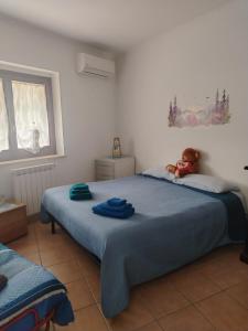a teddy bear sitting on a bed in a bedroom at Casa dell'orso in Rocca di Botte