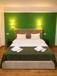 a bedroom with a large bed with green walls at BB Old City in Tbilisi City