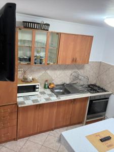 a kitchen with a sink and a stove top oven at Apartament Floare de Colț in Buşteni