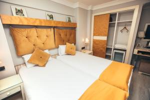 a bedroom with a large white bed with yellow pillows at Just Inn Hotel in Istanbul