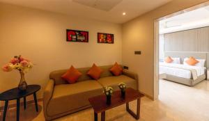 a living room with a couch and a bed at Fortune Plaza Hotel in Udupi