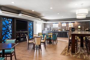 a restaurant with tables and chairs and a bar at Garner Hotel Liberal North by IHG in Liberal