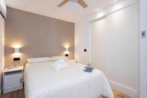 a white bedroom with a bed with a white blanket at Eden Rentals Olympia Sunny Seaviews in Playa de las Americas +14 photos