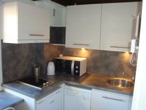 a kitchen with white cabinets and a microwave and a sink at New ! VUE PETITE VENISE-PLACE TO BE - PARKING in Colmar
