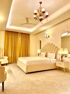 a large bedroom with a large bed and a chandelier at The Arte in Rohtak