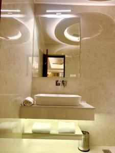 a bathroom with a sink and a mirror at The Arte in Rohtak