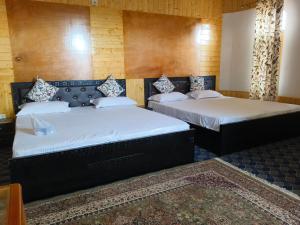 zwei Betten stehen in einem Zimmer mit in der Unterkunft Bashaw Residency Top Rated In Srinagar Only 6 Kms from Srinagar International Airport And Only 5 Kms From Srinagar Railway Station in Srinagar