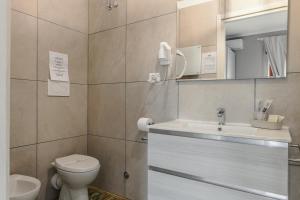 a bathroom with a toilet and a sink and a mirror at Malù House in Fiumicino