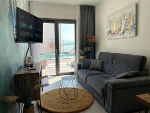 a living room with a blue couch and a tv at Slatine Residence Apartament No 1 in Slatine