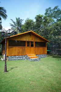a small wooden building in a field of grass at Annmees Freedom Land in Bangalore