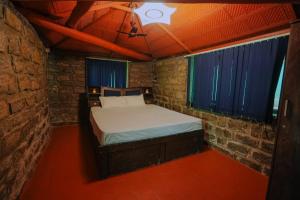 a small bedroom with a bed in a brick wall at Annmees Freedom Land in Bangalore +21 photos