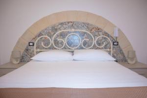 a bed with a decorative headboard in a bedroom at Galati House in Melendugno
