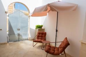 two chairs and a table and an umbrella in a room at Galati House in Melendugno +32 photos