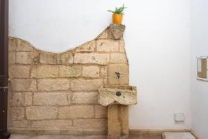 a brick wall with a plant on top of it at Galati House in Melendugno