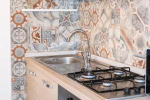 a kitchen with a sink and a stove at Galati House in Melendugno
