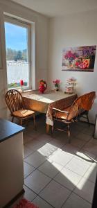 ein Zimmer mit einem Tisch, zwei Stühlen und einem Fenster in der Unterkunft Harzspaß in Braunlage