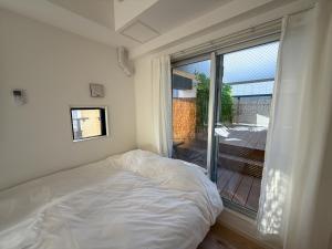 a bedroom with a bed and a large window at KOTI Hakata in Fukuoka