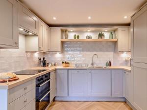 a kitchen with white cabinets and a sink at 1 Bed in Ilkley oc-87569 in Ilkley +10 photos