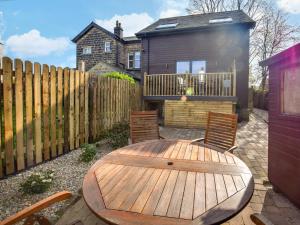 a wooden table and chairs in a backyard with a fence at 1 Bed in Ilkley oc-87569 in Ilkley