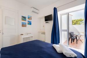 a bedroom with a blue bed and a balcony at Authentic Oasis - Villa La Solara in Anacapri