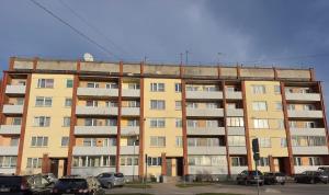 an apartment building with cars parked in a parking lot at Cozy 32 in Preiļi