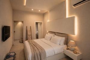 a bedroom with a large white bed and a tv at Palermo Inn Boutique Hotel in Palermo