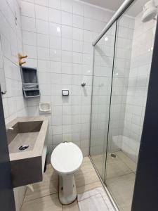 a bathroom with a toilet and a glass shower at Hotel Lords in Brasília