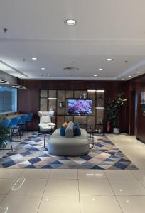 a lobby with a tv and a couch in a room at Courtyard by Marriott Duesseldorf Hafen in Düsseldorf