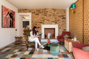 a woman sitting in a chair reading a book in a living room at Dimora Moncher in Montignoso