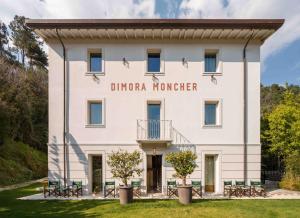 a white building with a sign that reads dino manor at Dimora Moncher in Montignoso