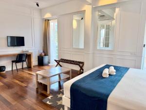 a bedroom with a bed and a table and a tv at Grand Hotel Urban in Antananarivo