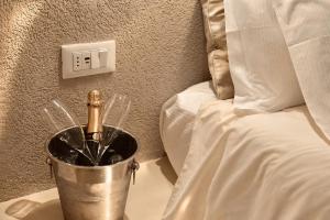 a bucket with a champagne bottle in it next to a bed at Palermo Inn Boutique Hotel in Palermo