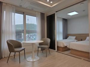 a bedroom with a bed and a table and chairs at TRAVELUS Myeongdong 트래블어스 명동 in Seoul