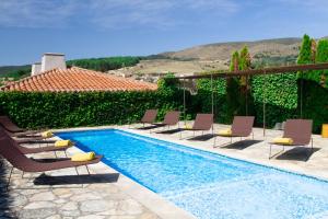 a swimming pool with lounge chairs next to a house at Belle Torre Mayorazgo Boutique Hotel in Villatoro