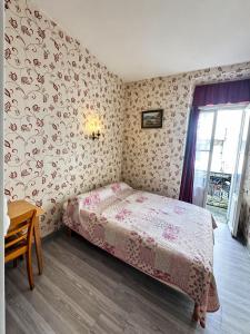 a small bedroom with a bed and a table at Hotel Saint Francois Xavier in Lourdes +8 photos