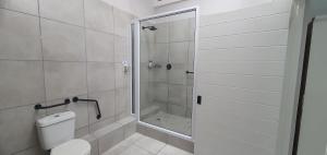 a white bathroom with a shower and a toilet at Point Village Hotel and Self Catering in Mossel Bay +154 photos